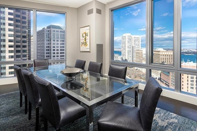 dining space with visible vents, a view of city, and wood finished floors