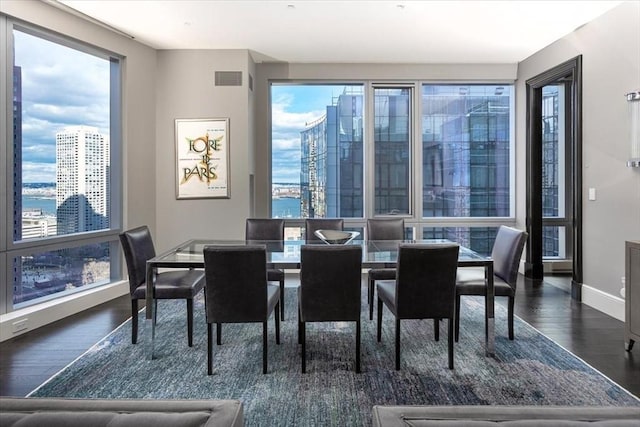 dining area featuring visible vents, baseboards, and wood finished floors