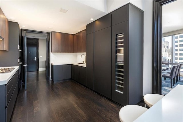 kitchen with dark wood-style floors, modern cabinets, light countertops, and a sink