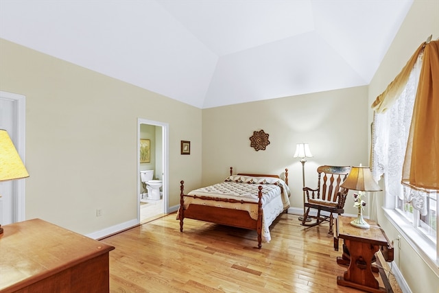 bedroom with ensuite bathroom, light wood-type flooring, and lofted ceiling