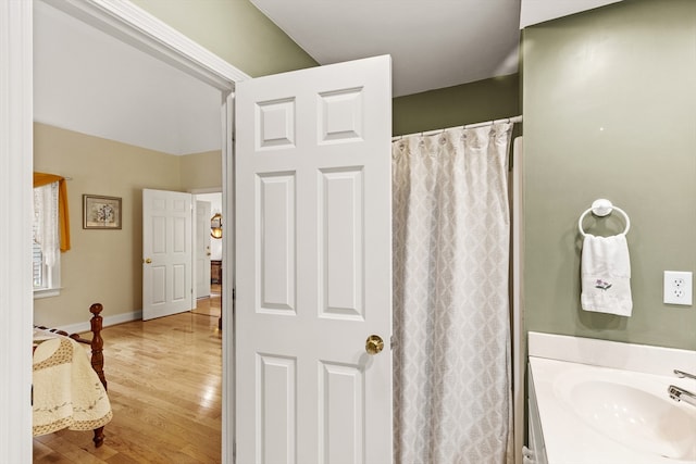 bathroom with walk in shower, vanity, and hardwood / wood-style flooring