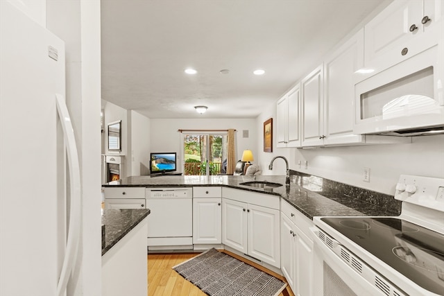 kitchen featuring white appliances, sink, light hardwood / wood-style floors, white cabinets, and kitchen peninsula