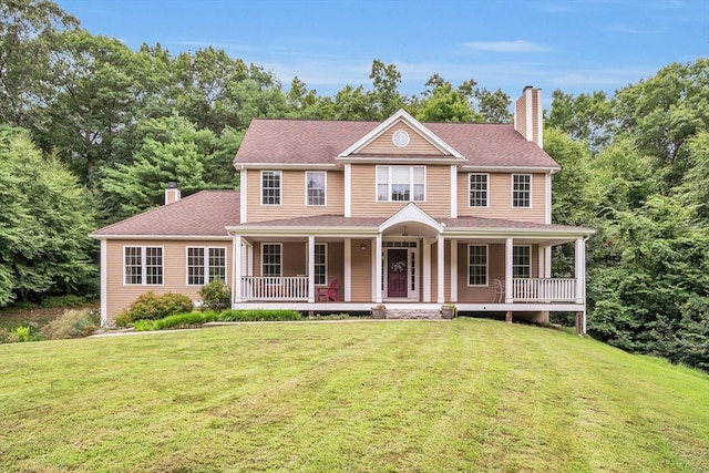 view of front of property with a chimney, a front yard, and a porch