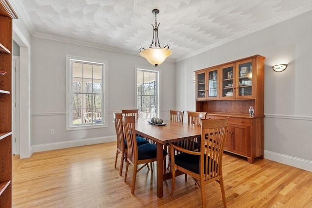 dining room with light wood-style floors, baseboards, and ornamental molding