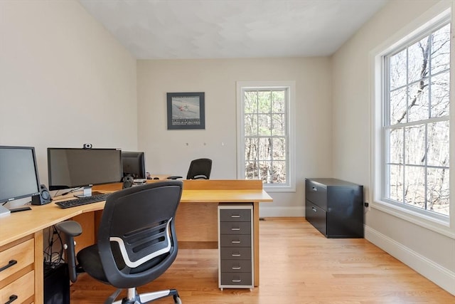 home office with light wood finished floors and baseboards