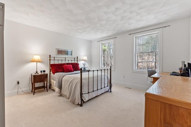 bedroom with light carpet, baseboards, and a textured ceiling