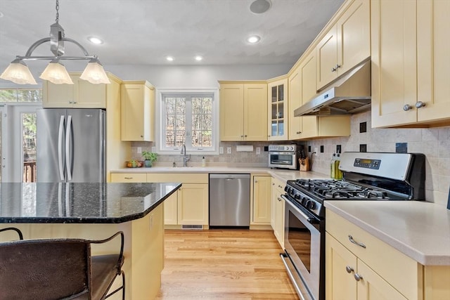 kitchen featuring appliances with stainless steel finishes, under cabinet range hood, healthy amount of natural light, a sink, and recessed lighting