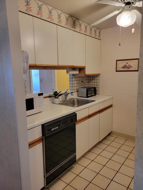 kitchen with black dishwasher, light countertops, white cabinets, and white microwave