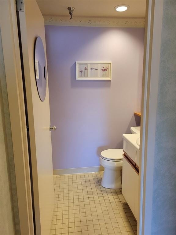 bathroom featuring baseboards, tile patterned flooring, vanity, and toilet