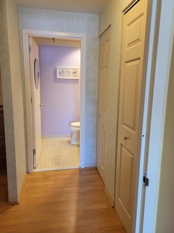 hall with light wood-style floors and baseboards