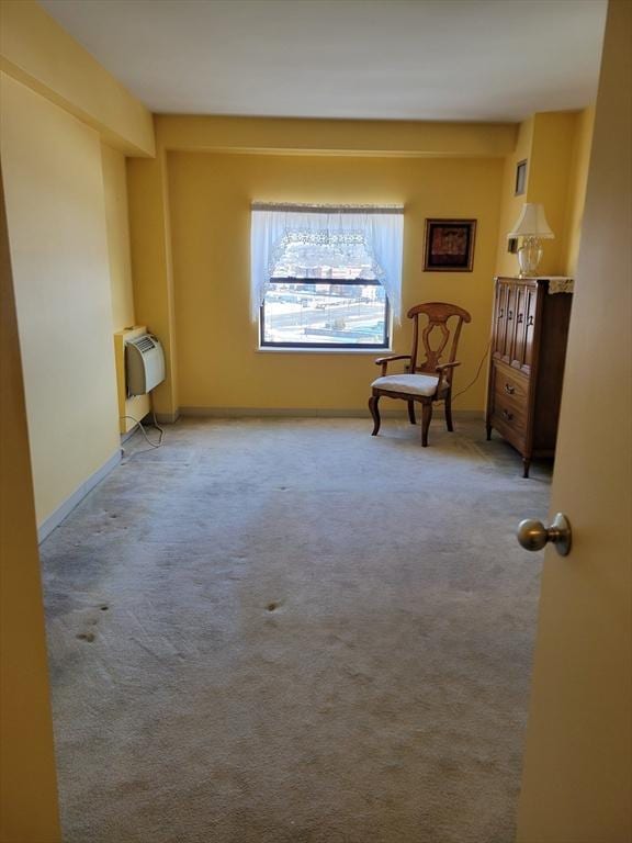 sitting room with carpet flooring, baseboards, and heating unit