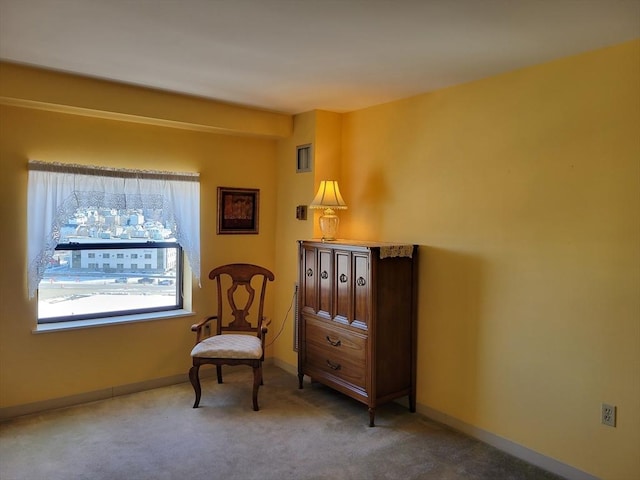 living area featuring carpet flooring and baseboards
