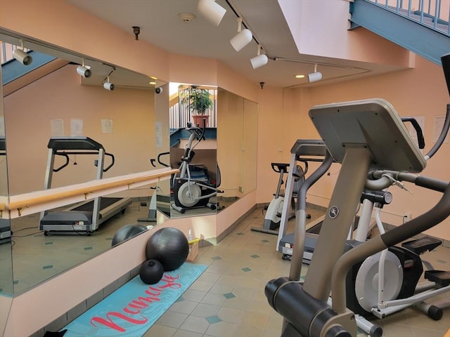 exercise room featuring rail lighting