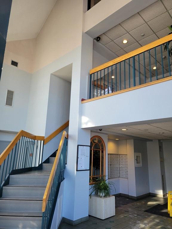 stairway with a high ceiling, visible vents, and baseboards