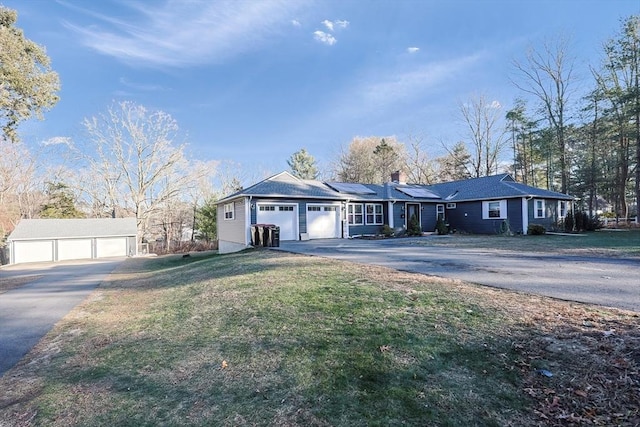 ranch-style house featuring a garage, a front yard, and solar panels