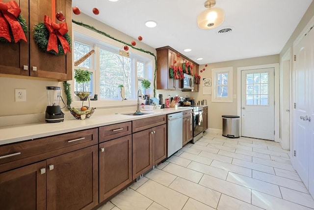 kitchen featuring light tile patterned floors, stainless steel appliances, plenty of natural light, and sink