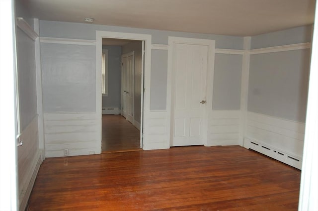 spare room featuring a baseboard radiator and wood finished floors