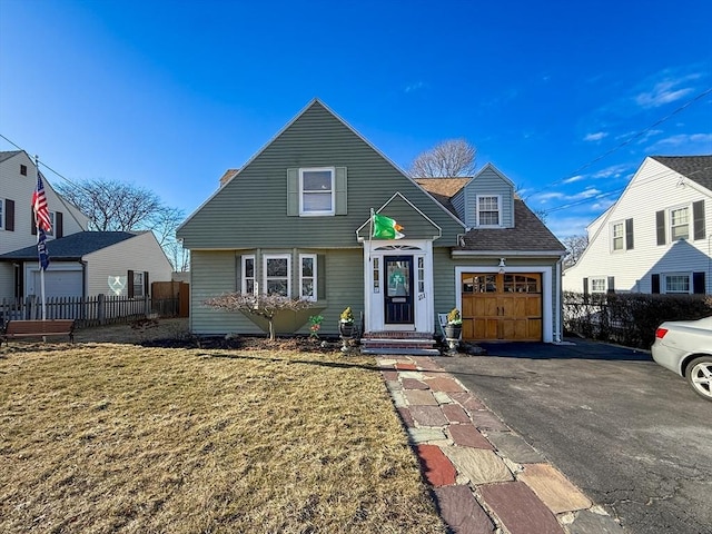 view of front of home featuring an attached garage, driveway, roof with shingles, and fence