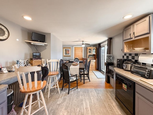 kitchen with black dishwasher, recessed lighting, a toaster, light wood-style floors, and light countertops