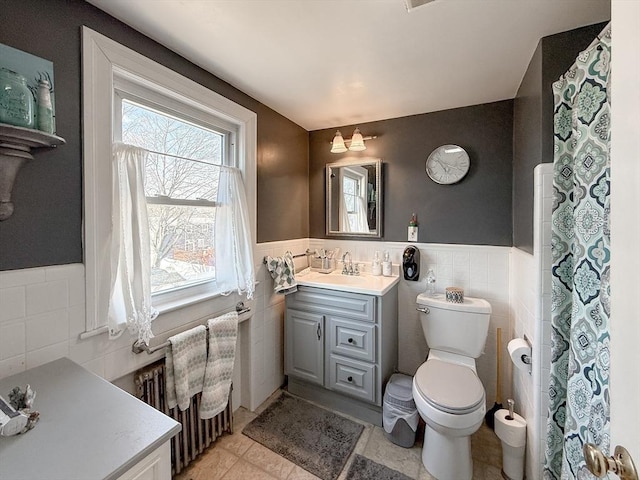 bathroom featuring toilet, radiator, tile walls, wainscoting, and vanity