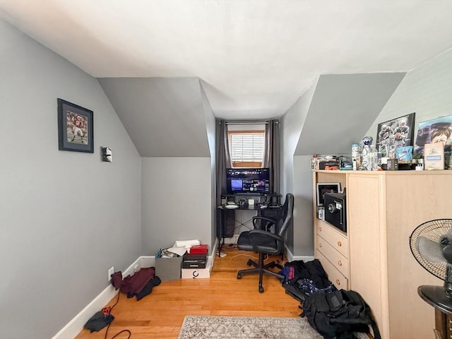 home office featuring lofted ceiling, wood finished floors, and baseboards