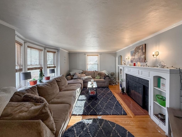 living room featuring a fireplace with flush hearth, light wood-style floors, ornamental molding, and a textured ceiling