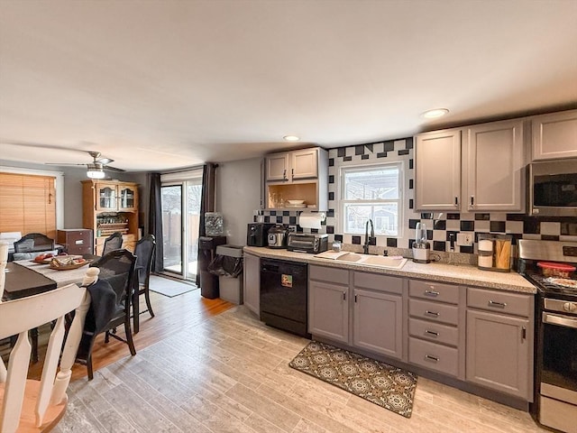 kitchen with a sink, stainless steel appliances, and gray cabinetry