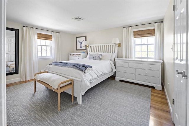 bedroom with wood finished floors and baseboards