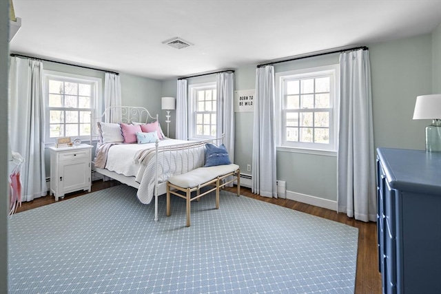 bedroom with dark wood-style flooring, multiple windows, and baseboards