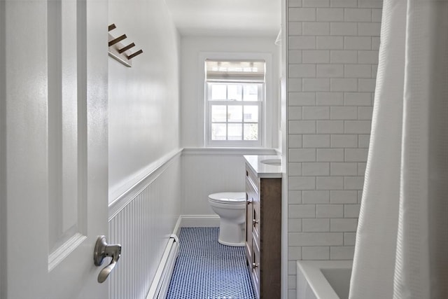 bathroom featuring toilet, a wainscoted wall, vanity, and tile patterned floors