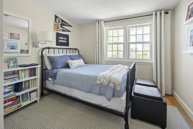 bedroom featuring baseboards and wood finished floors