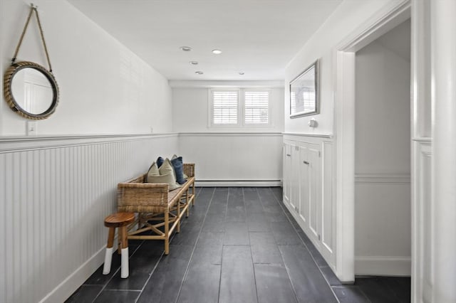 hallway with a baseboard radiator and a wainscoted wall