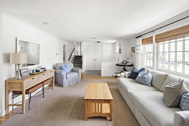 living area with stairs, light wood-type flooring, and a baseboard radiator