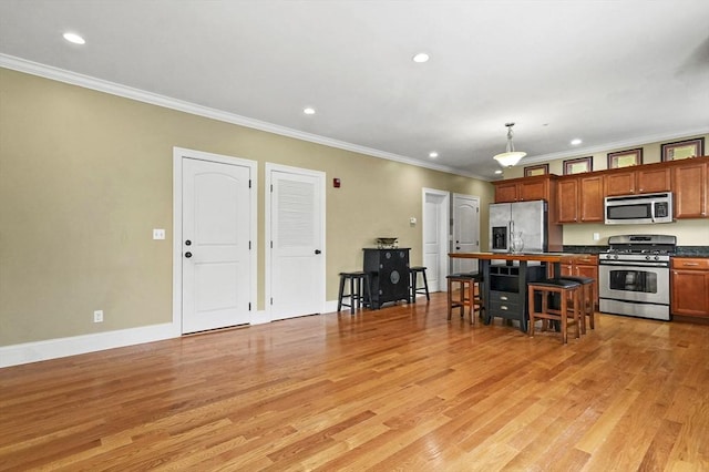 75 Pine St Unit 21, Waltham, MA 02453 - kitchen with stainless steel appliances, ornamental molding, light wood-style flooring, dark countertops, and recessed lighting