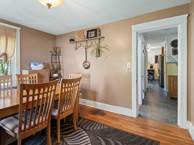 dining space featuring wood finished floors and baseboards