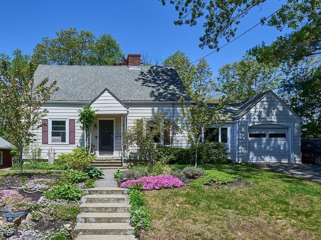 cape cod house with an attached garage, a chimney, a front lawn, roof with shingles, and driveway