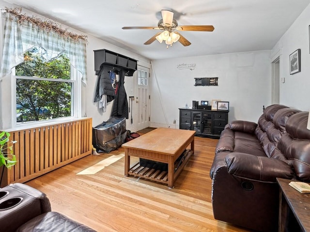 living area featuring light wood finished floors and ceiling fan