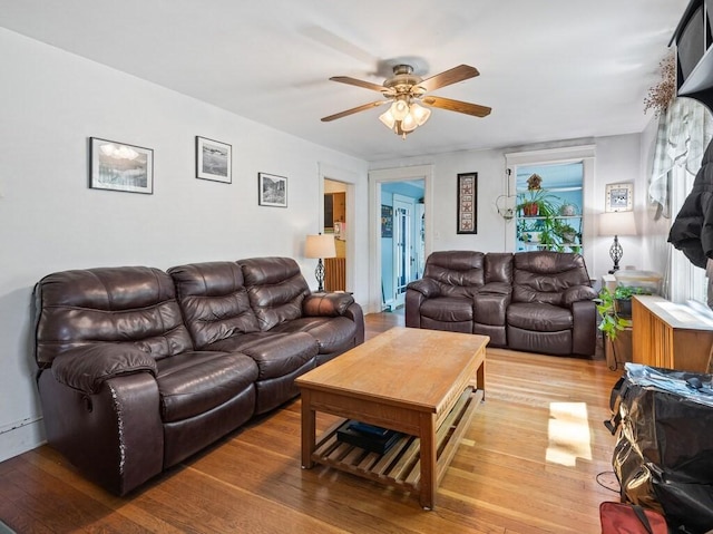 living area with ceiling fan and light wood finished floors