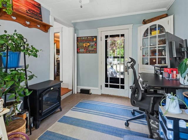 office area featuring ornamental molding and a wood stove