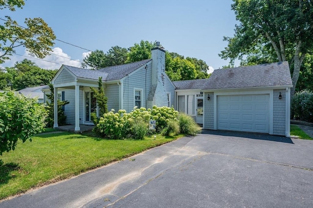 46 Pine, Falmouth, MA 02556 - view of front of property with asphalt driveway, a chimney, an attached garage, a front lawn, and roof with shingles