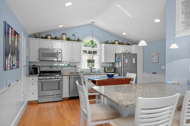 46 Pine, Falmouth, MA 02556 - kitchen featuring stainless steel appliances, lofted ceiling, a wainscoted wall, light wood finished floors, and white cabinets
