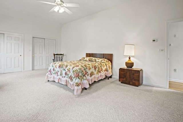 bedroom featuring two closets, carpet flooring, baseboards, and ceiling fan
