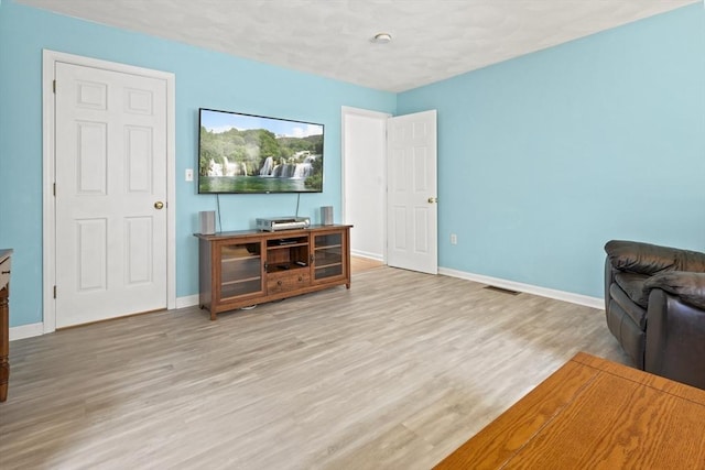 living area with wood finished floors and baseboards