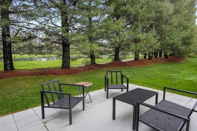 view of home's community featuring a water view, a yard, a patio, and view of scattered trees