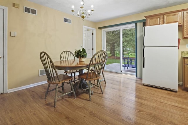 dining space with a chandelier, light wood-type flooring, and baseboards