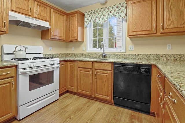 kitchen featuring white gas range oven, black dishwasher, under cabinet range hood, a sink, and light wood-type flooring