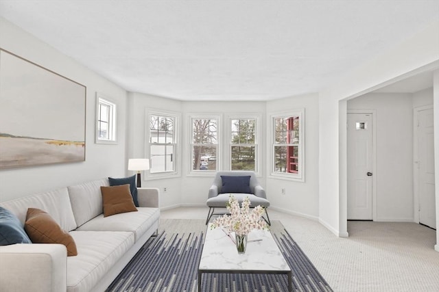 carpeted living area with baseboards