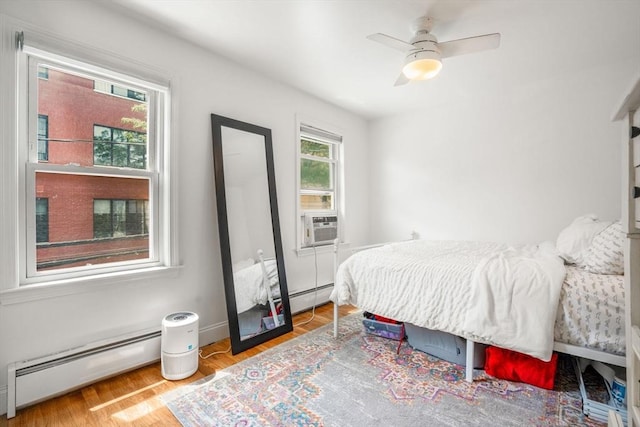 122 W 9th St Unit 2, Boston, MA 02127 - bedroom featuring baseboard heating, wood finished floors, a ceiling fan, and cooling unit