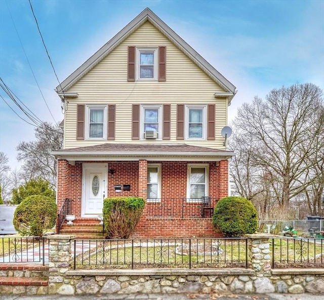 view of front of home featuring cooling unit, a fenced front yard, covered porch, and brick siding