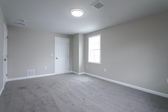 empty room featuring visible vents, baseboards, and carpet